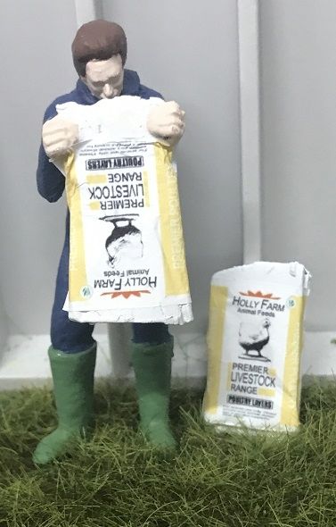 WM078K - Bauer entleert einen Beutel mit Geflügelfutter - 1